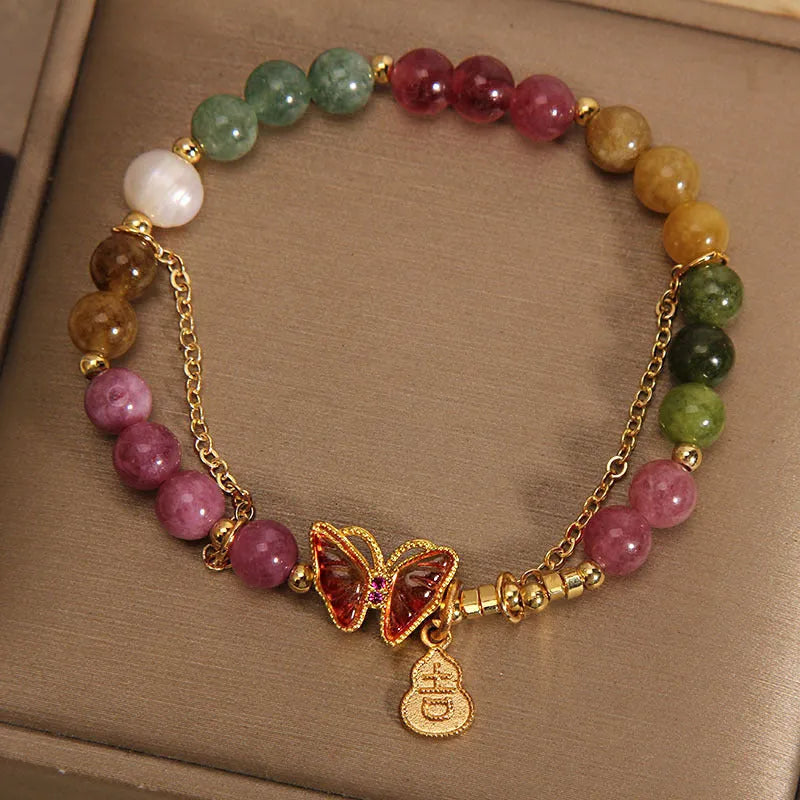Women's agate and tourmaline bracelet with a detailed butterfly-shaped gourd charm in natural jade colours.