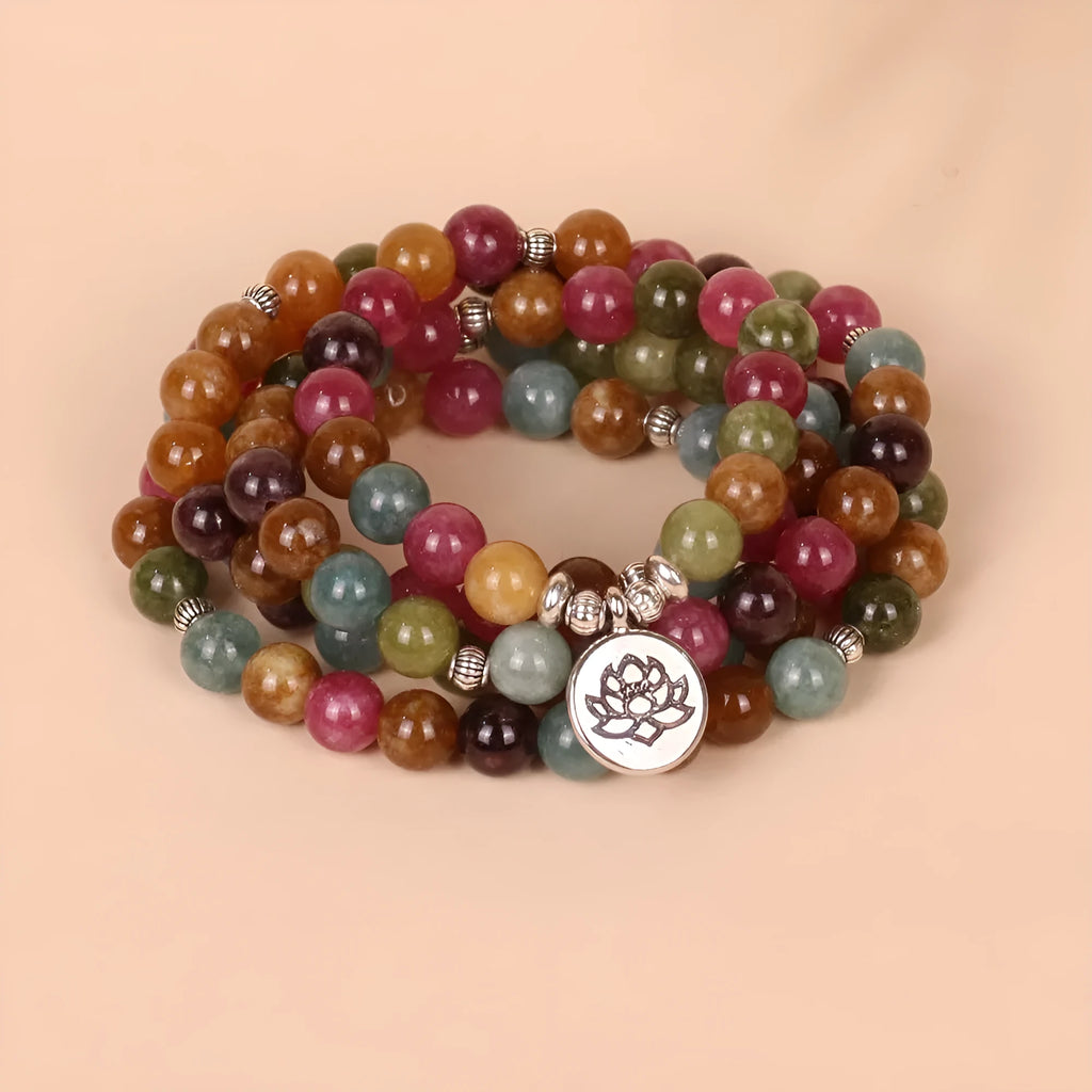 Close-up of a 108-bead alloy bracelet with a multi-layer lotus string design in a tourmaline colour.