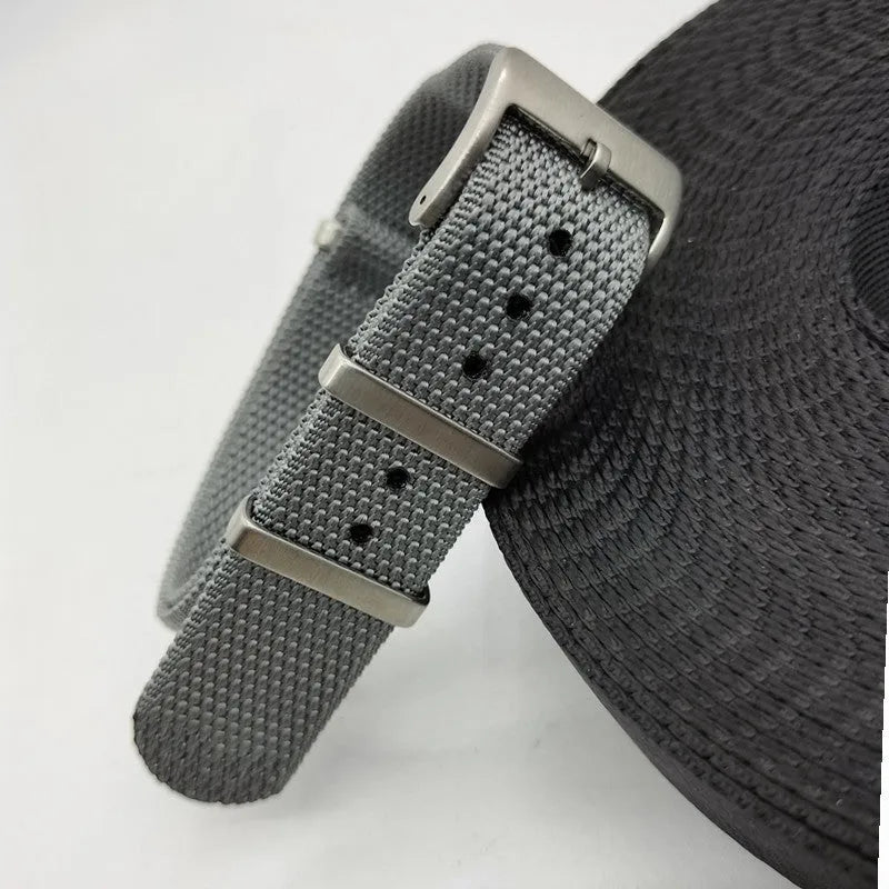 Nylon textile watch strap in army green colour with metal buckle, shown alongside black and blue options.