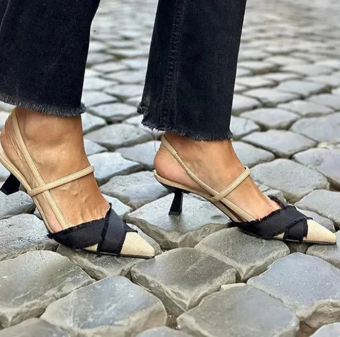 Apricot and black women's stiletto sandals with a pointed toe and buckle fastening on a white background.
