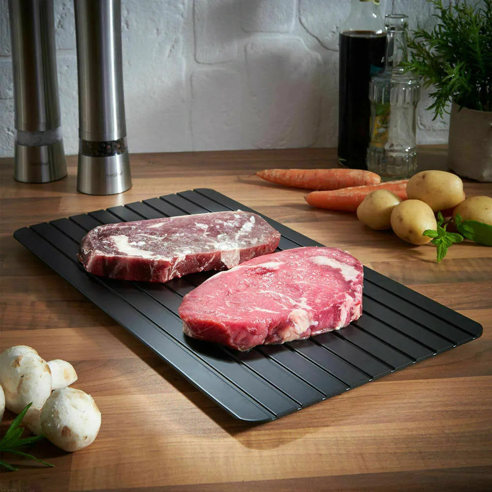 Black aluminium fast defrosting tray for thawing frozen meat and food.