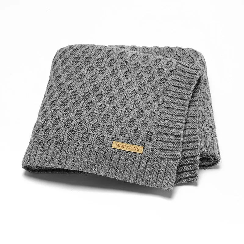 Solid colour acrylic infant blanket with textured lines, shown in a choice of five colours.