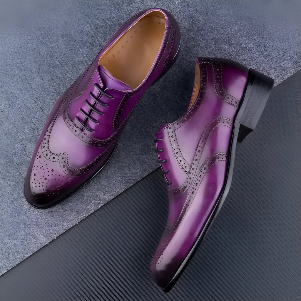 Men's purple leather oxford shoes with hand-carved detailing and a pointed toe on a rubber sole.