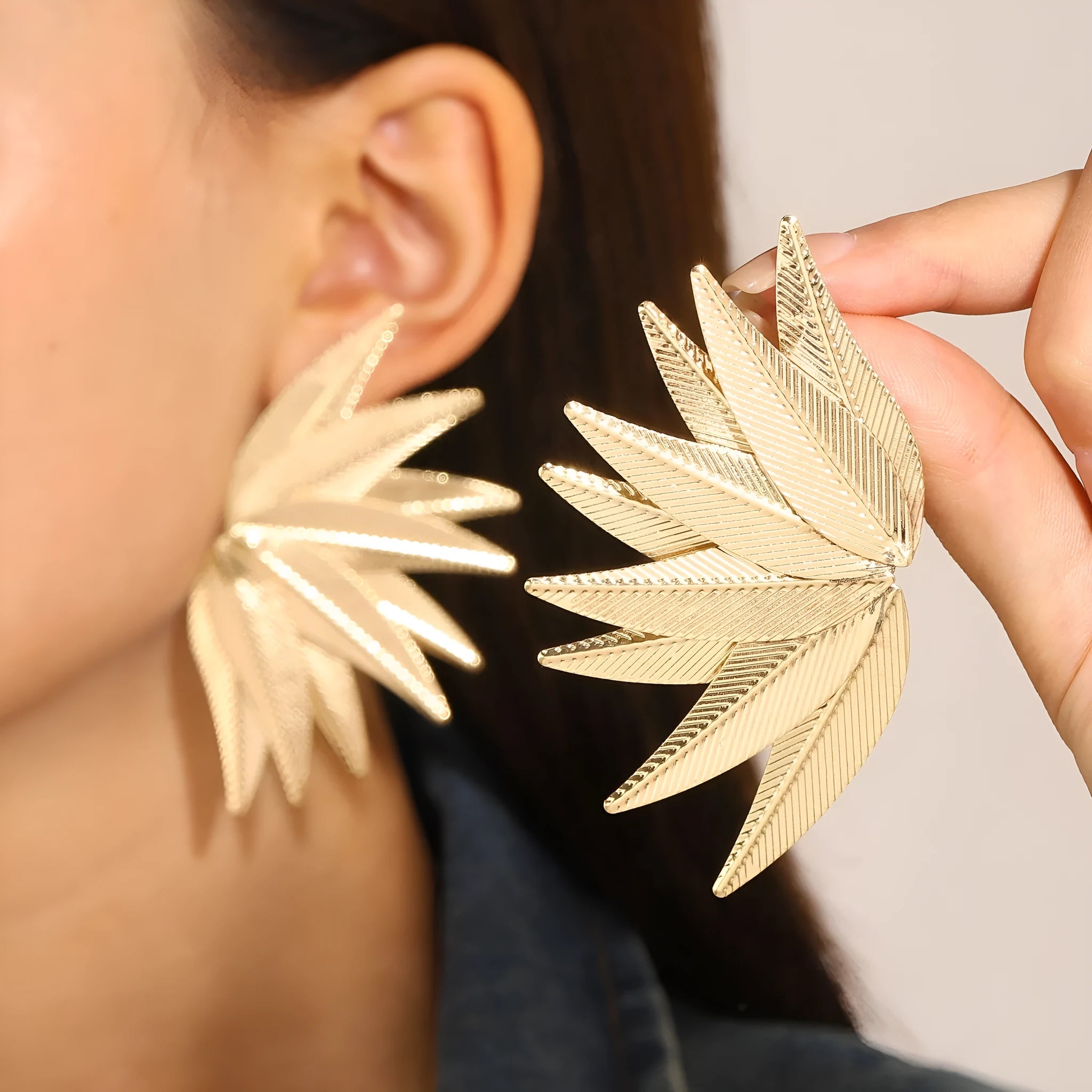 Leaf-shaped patch earrings in gold or white alloy with stud back closure