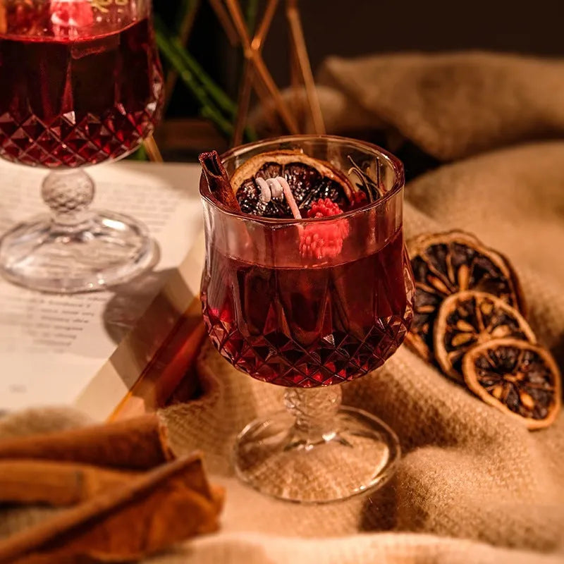 Clear glass wine goblet containing a scented candle with French mulled wine style