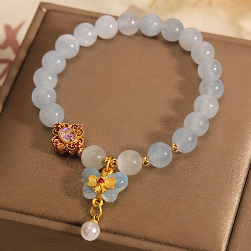 Women's crystal bracelet with aquamarine butterfly pendant and rhinestone detailing.
