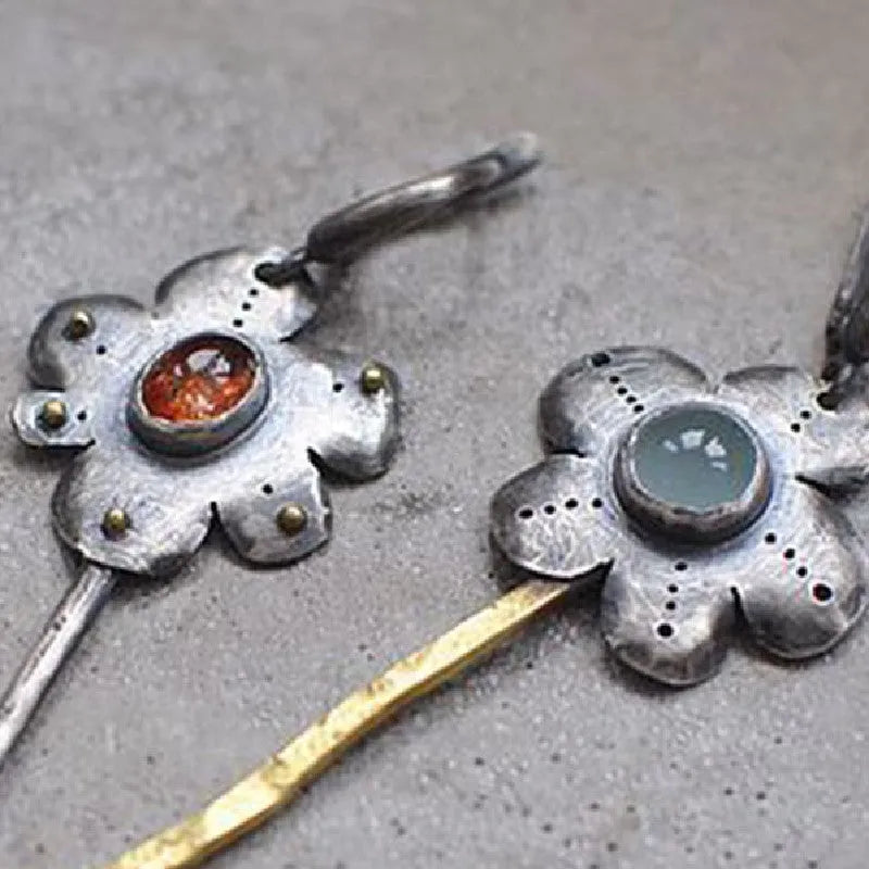 A pair of long retro earrings with asymmetric geometric flower shapes in a two-tone electroplated finish.