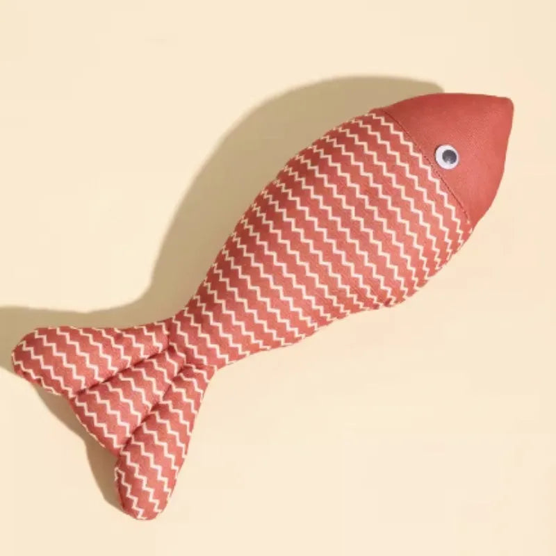 Yellow catnip fish plush chew toy for cats lying on a wooden floor.