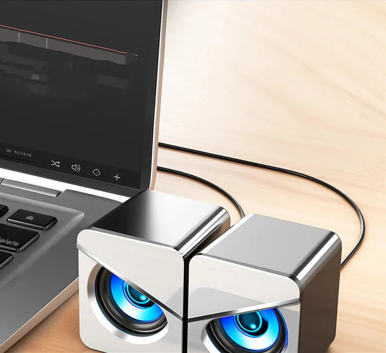 Compact black or white USB mini speaker for computer desktop use with wired connection.