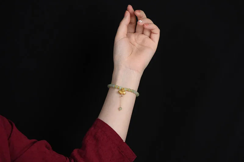 Two Shihuan natural Hetian jade bracelet with 6mm beads, fu charm, and lotus motif on a wrist.