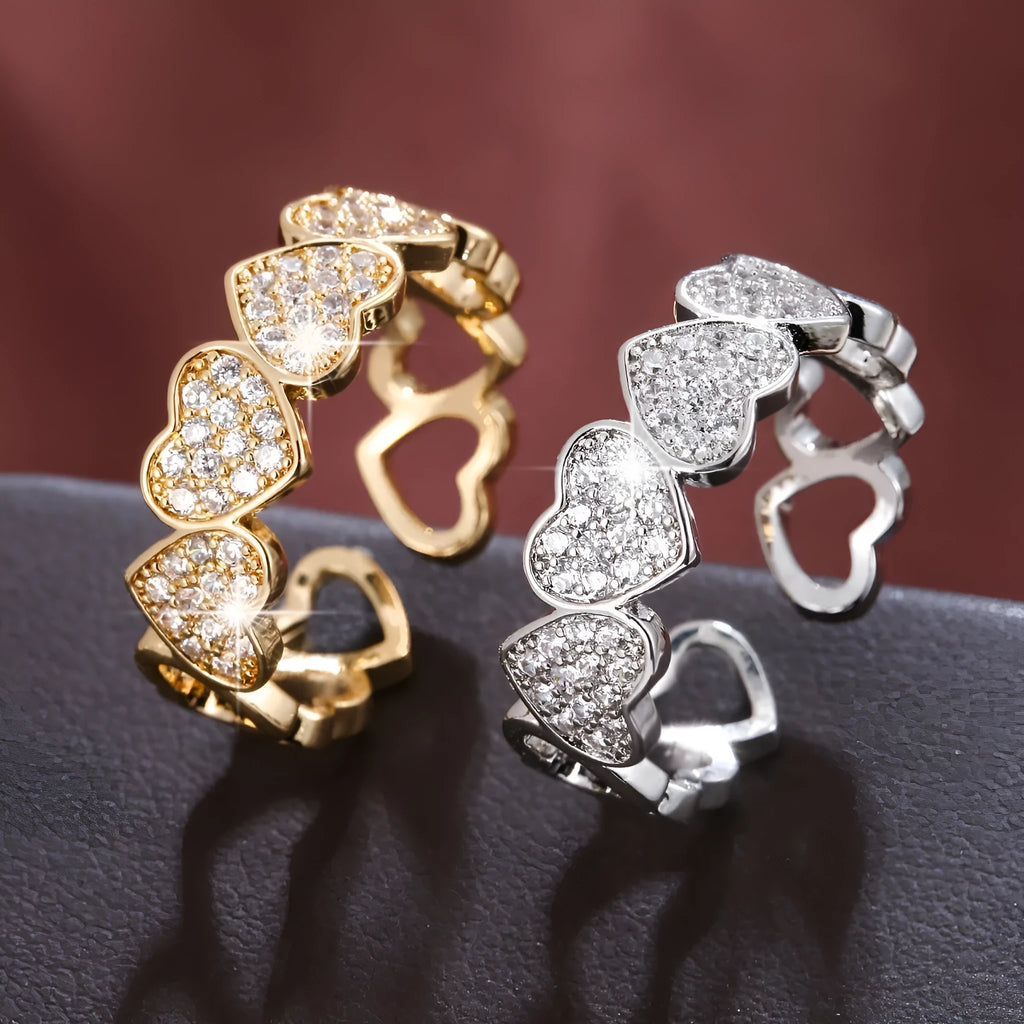 Gold and silver adjustable heart-shaped couples ring on a small finger.