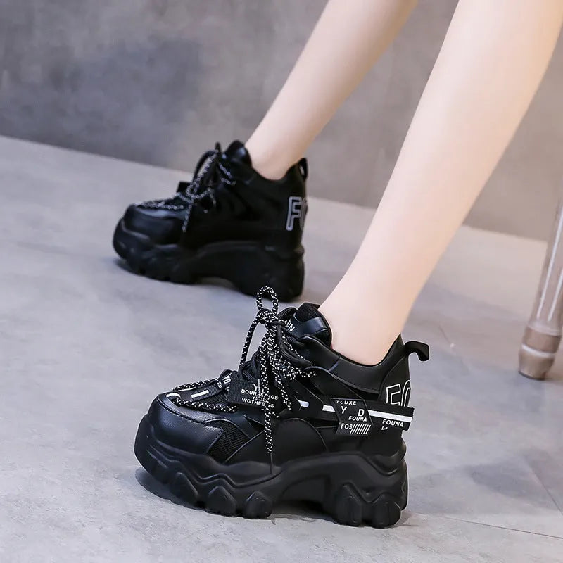 White and black women's low-top platform sports shoes with a cross strap and mesh upper.