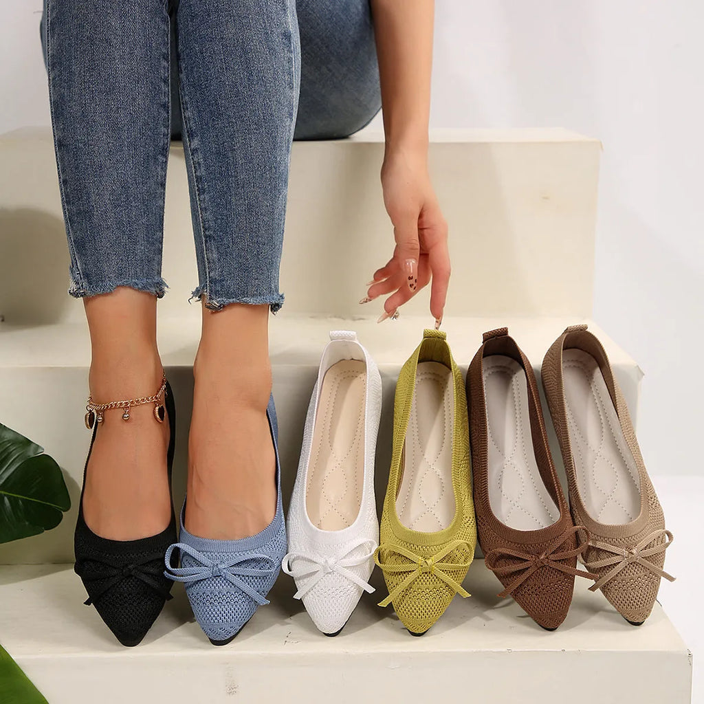 Women's knitted loafers with bow decoration in various colours showing flat rubber soles