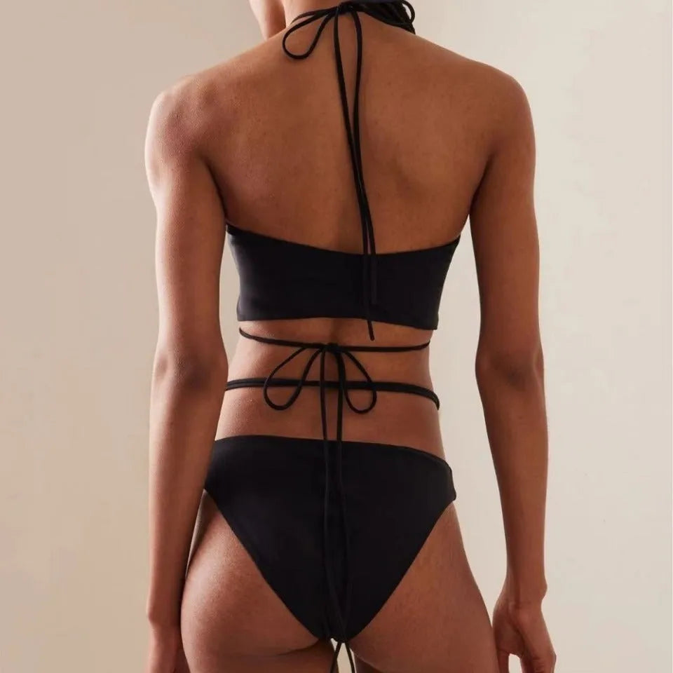 Women's black lace-up bikini swimsuit set with bra and shorts on white background
