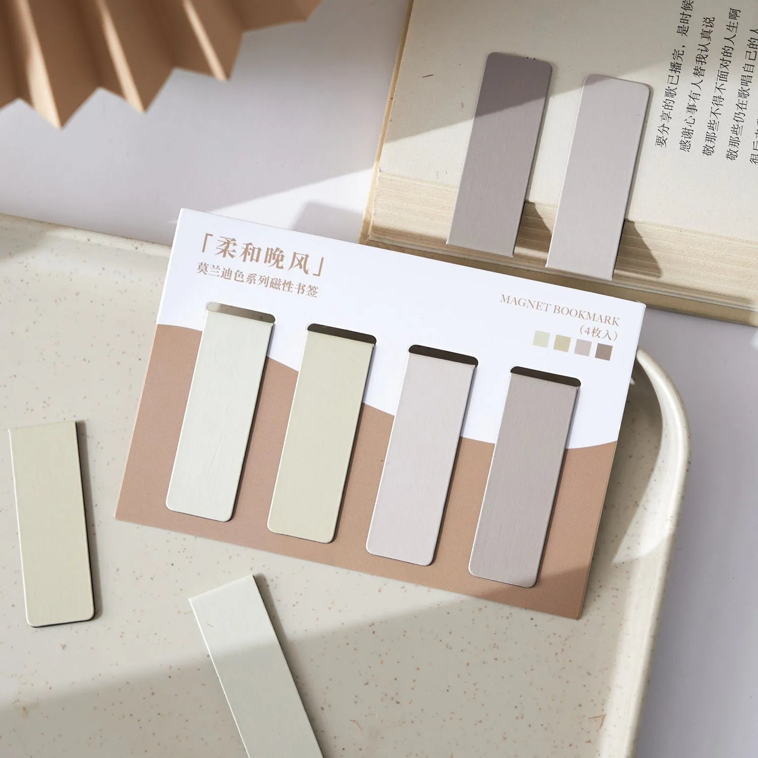 Set of four pastel colour block magnetic bookmarks from the Morandi series on a book page.