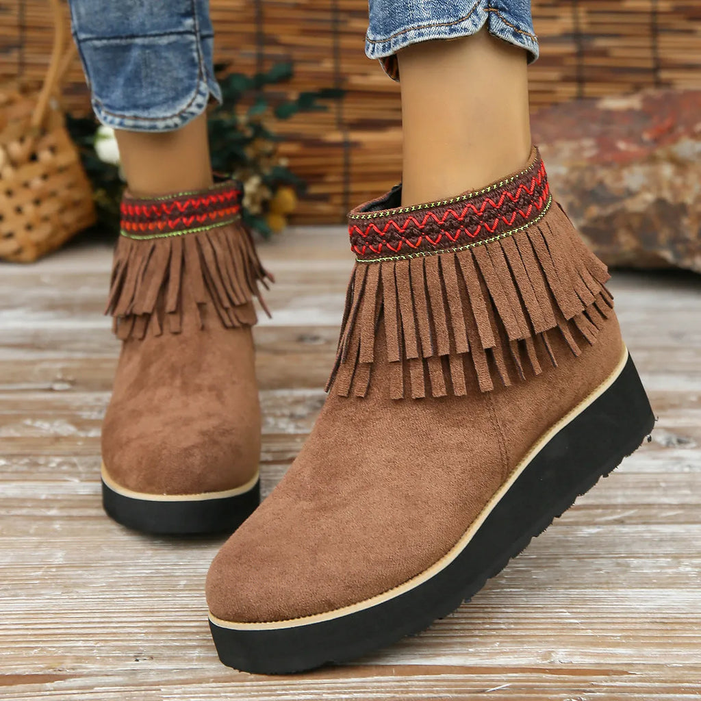 Women's dark brown suede wedge ankle boots with side zip and tassel detail on a thick rubber sole.