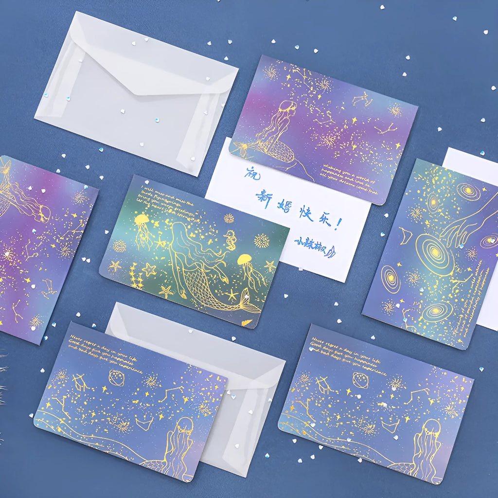 Three decorative paper envelopes with bronzing mermaid design in assorted colours