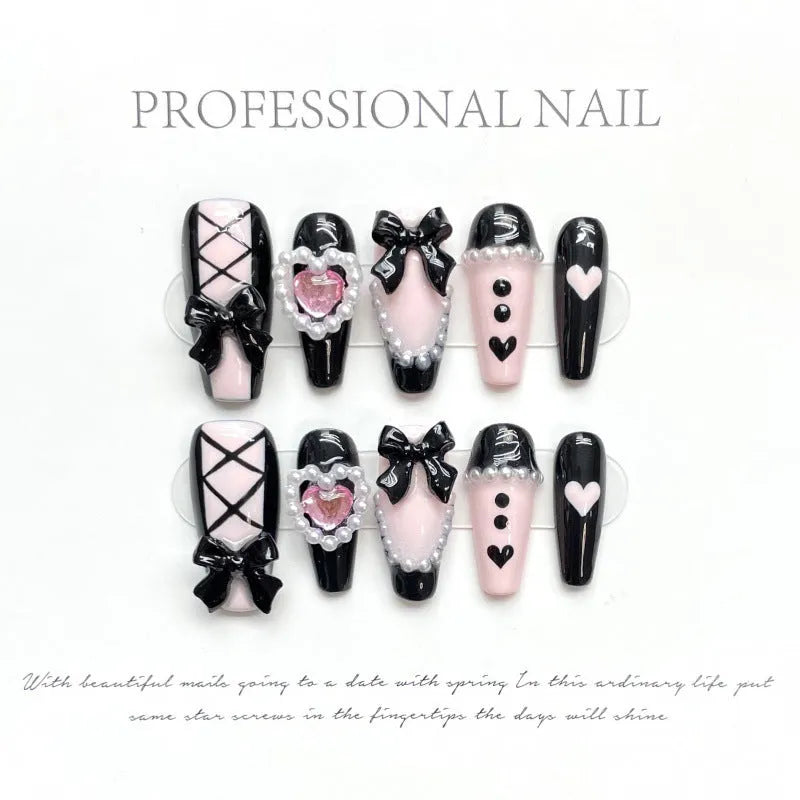 Handmade artificial nails with black and pink heart design and bow pattern in four sizes