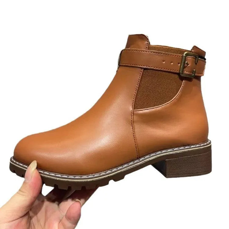 Black ankle boots with round toe and belt buckle decoration, showing rubber sole and waterproof artificial PU upper