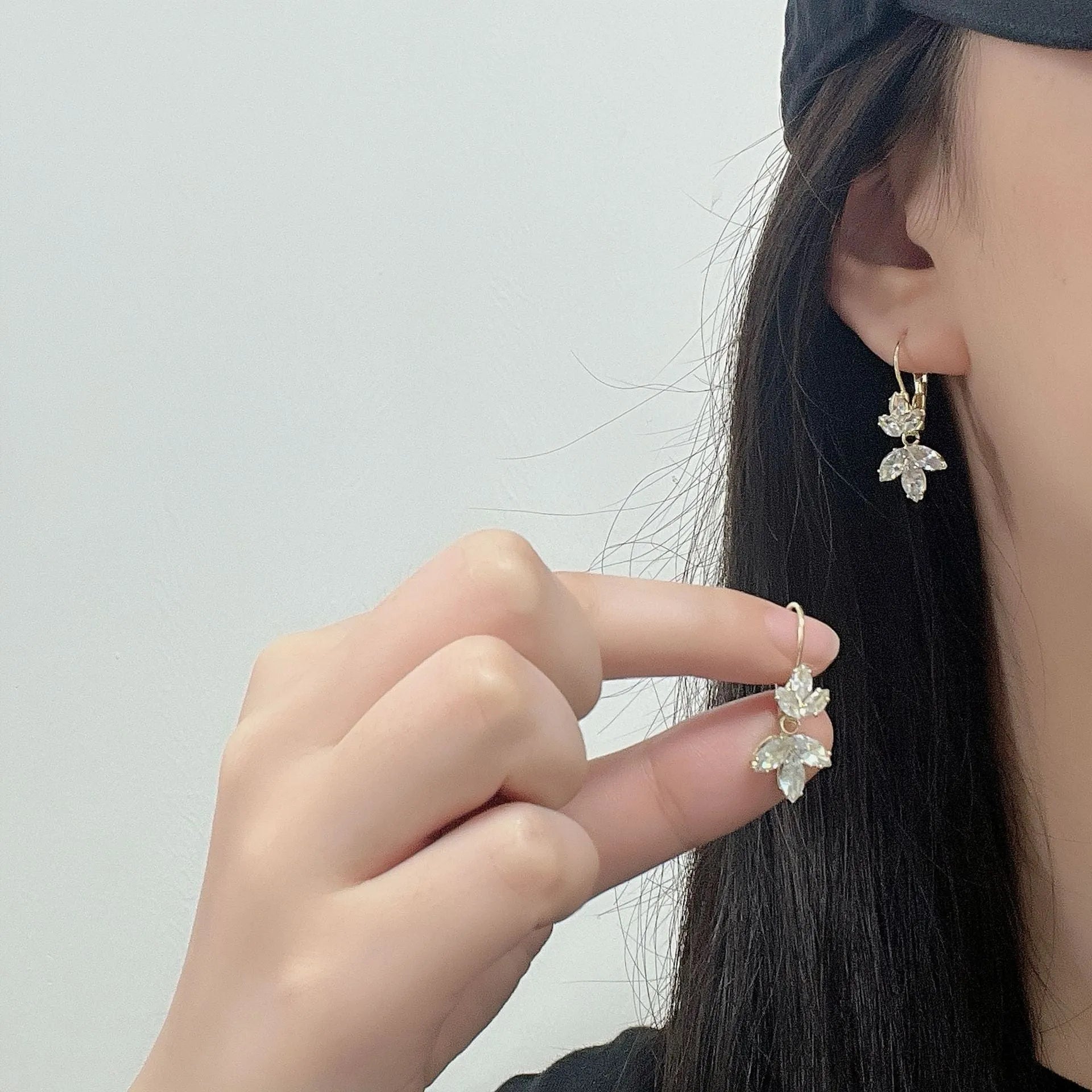 Platinum colour alloy earrings with leaves shape design featuring inlaid zircon stones