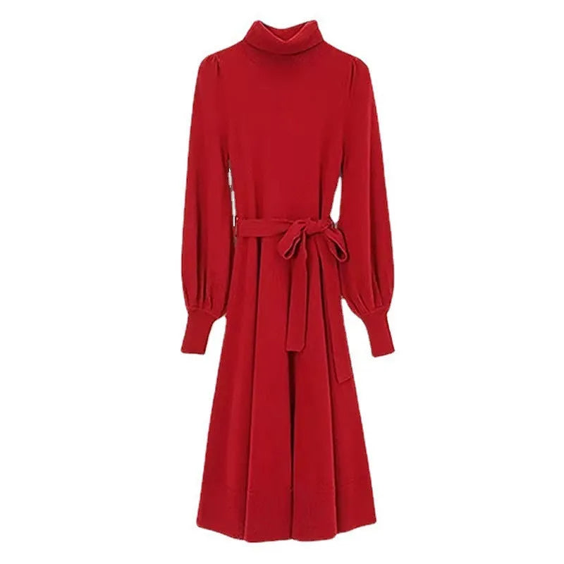 A woman wearing a rose red turtleneck long sleeve knitted dress with an elastic waist and a loose mid-length skirt.