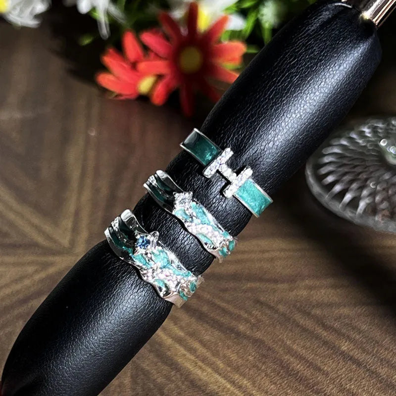 Mint green enamel asterism ring with copper base and eight-point star pattern on finger