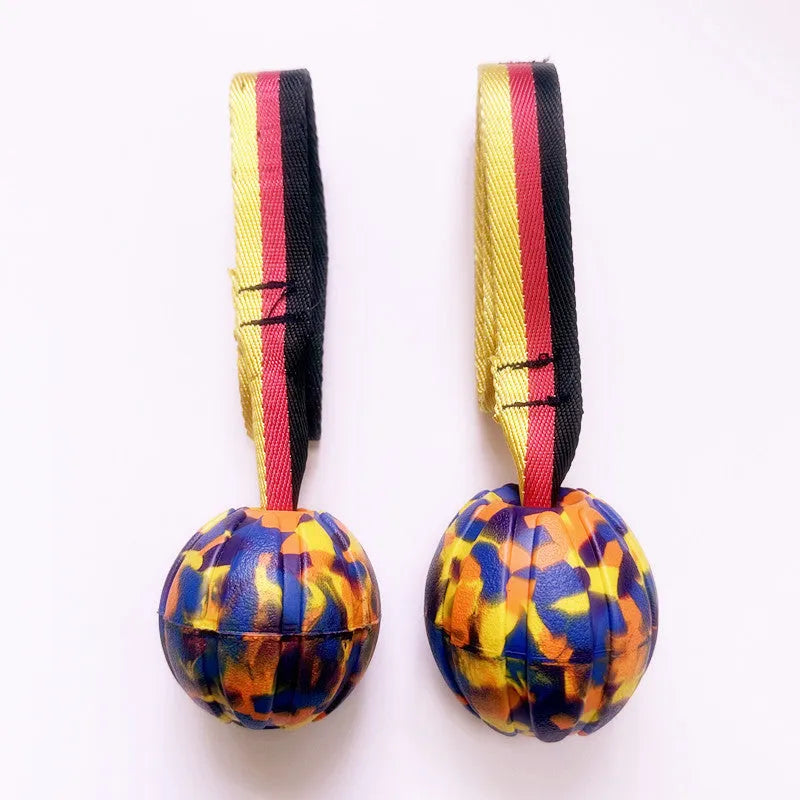 Yellow and camouflage coloured EVA floating dog tetherballs in different sizes on a blue background.