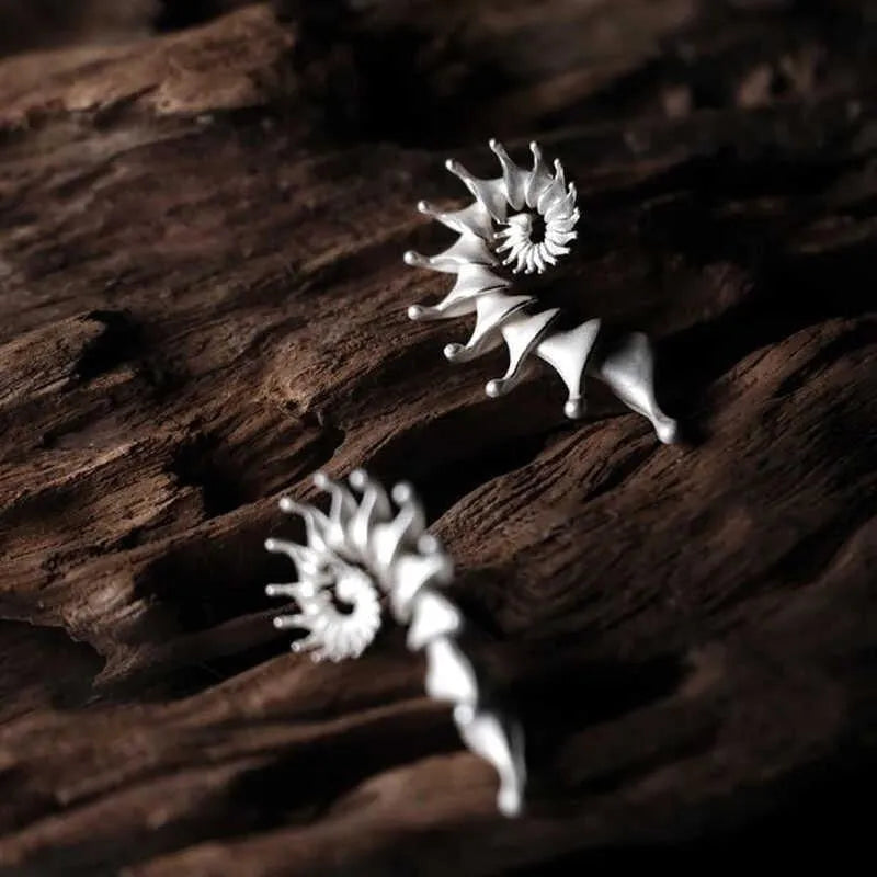 A pair of matte finish conch-coloured alloy stud earrings with a three-dimensional irregular shape.