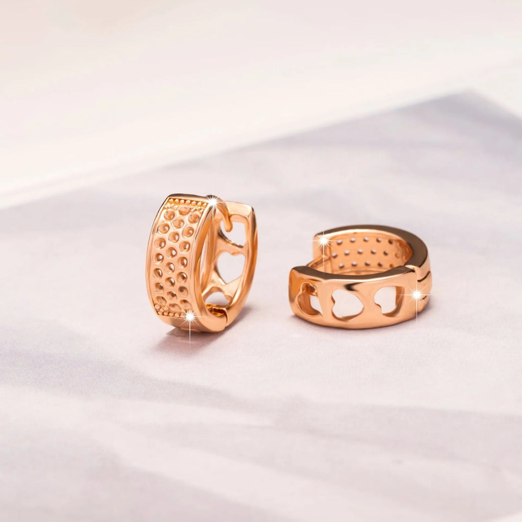 Rose gold hollowed out earrings with a three-heart design inside a circular shape.