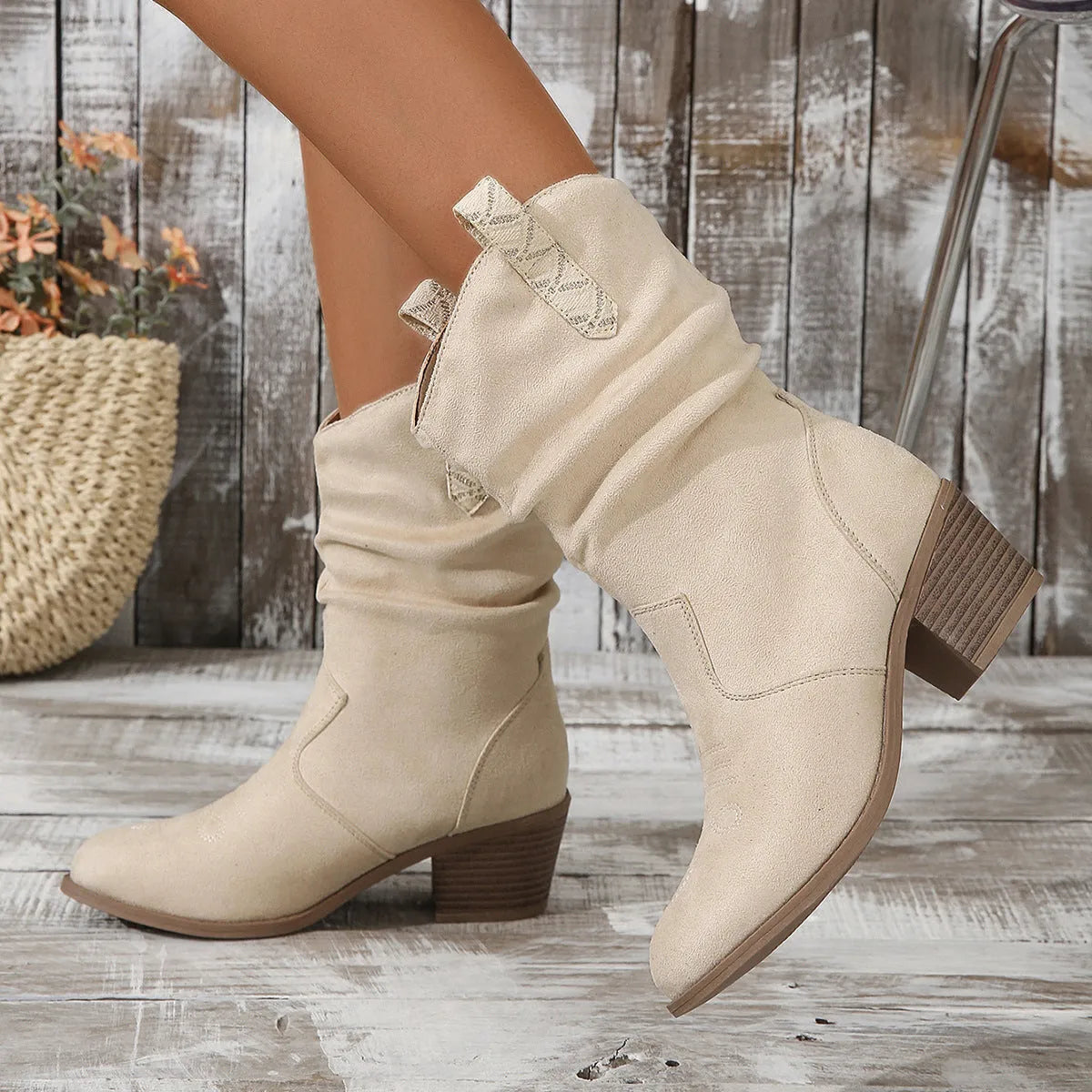 Milky white suede mid-calf boots with leather stitch detail and a mid-heel on a woman.