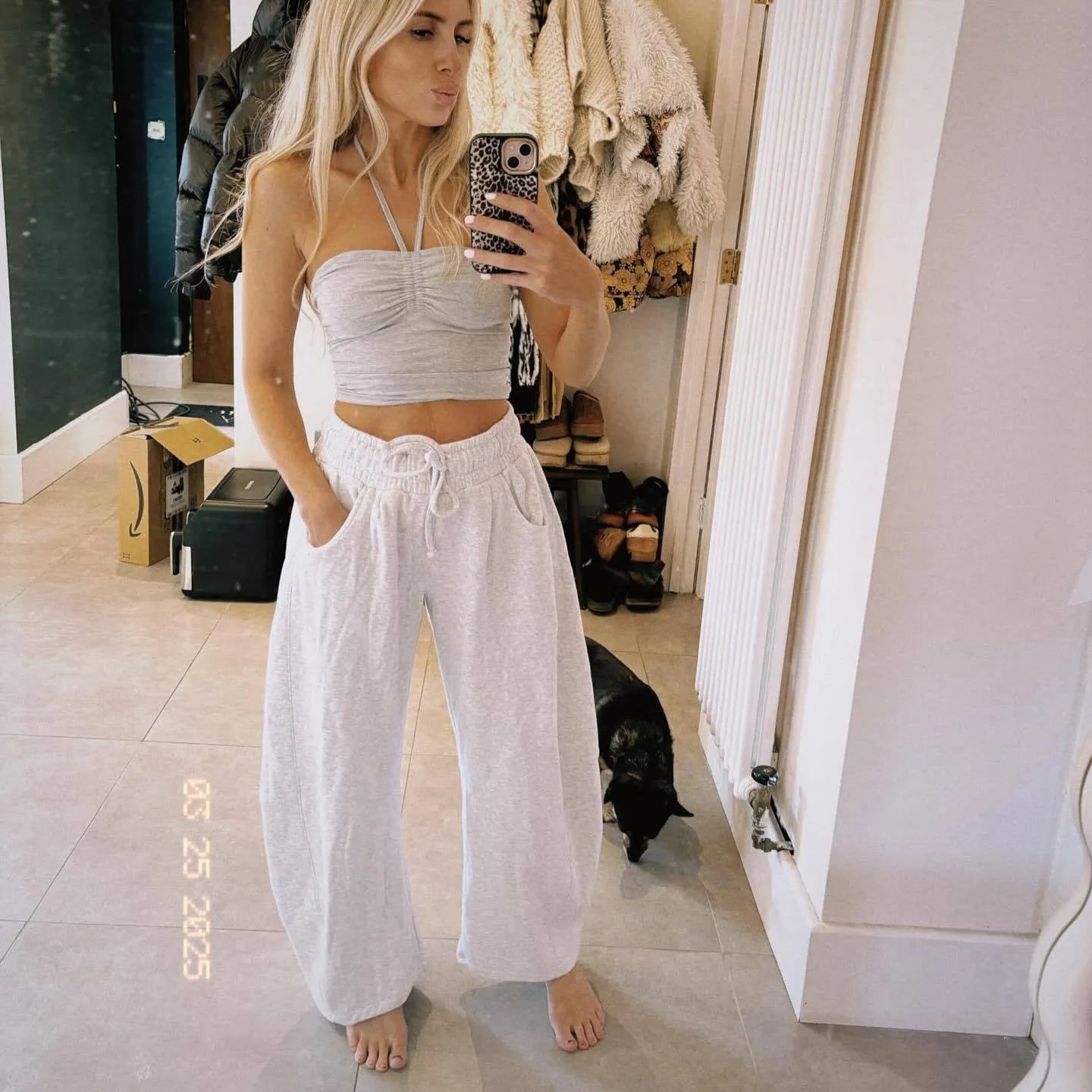 Loose fit cropped sweatpants in apricot colour with drawstring waist and side pockets on a neutral background.