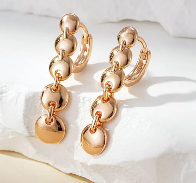 Gold retro long woven copper circle hoop earrings on a white background