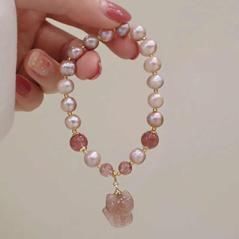 Women's light pink freshwater pearl bracelet with strawberry quartz and fox charm detailing