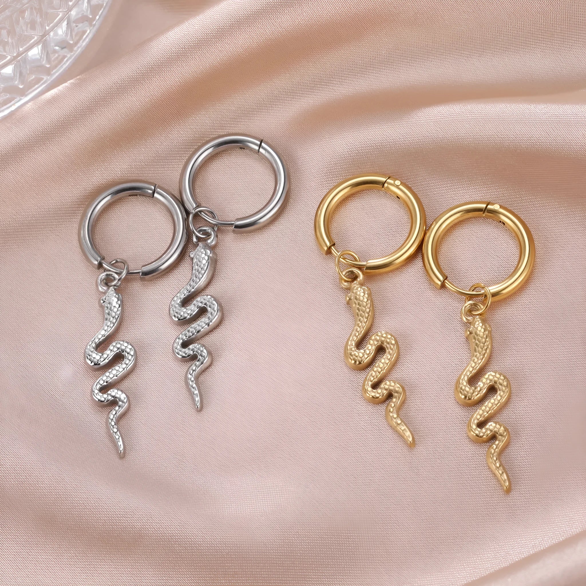 A pair of vintage-style snake-shaped earrings in stainless steel with a gold or steel electroplated finish.
