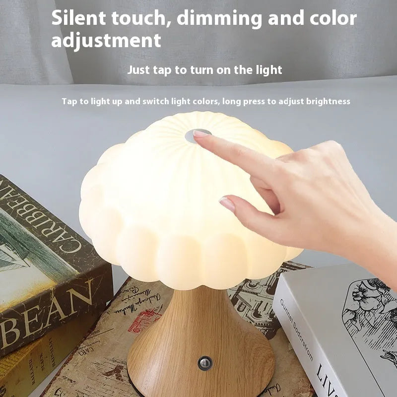 Touch control mushroom night light in wood grain colour on its wireless charging pad.