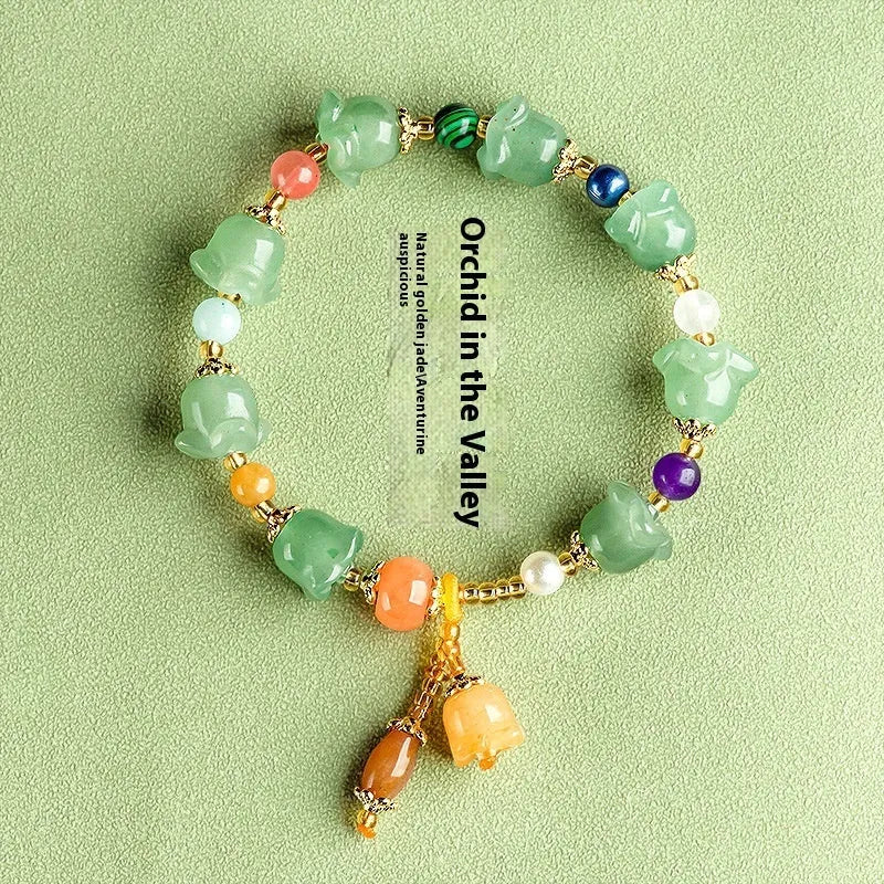 Natural Xinjiang Jinsi Jade aventurine orchid bracelet with carved orchid beads on a wrist.