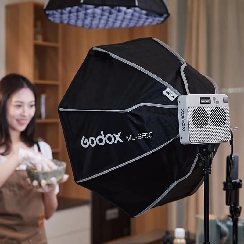 Shenniu ML100Bi photography fill light with aluminium body, two lenses, battery handle, and storage bag.