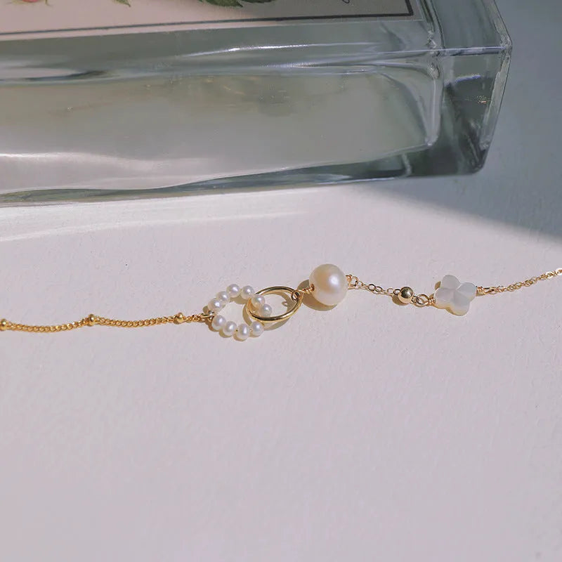 Women's natural pearl bracelet with 14k gold-plated clasp and chain.