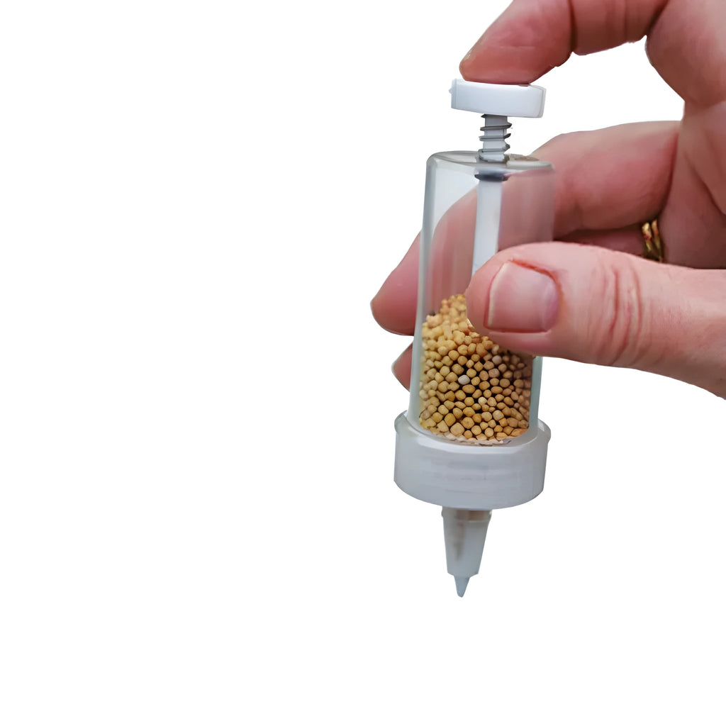 A 12cm long, 3cm diameter plastic mini garden seeder tool for dispensing seeds into pots.