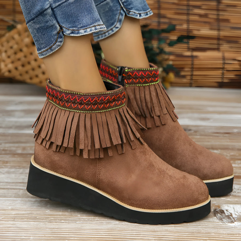 Women's dark brown suede wedge ankle boots with side zip and tassel detail on a thick rubber sole.