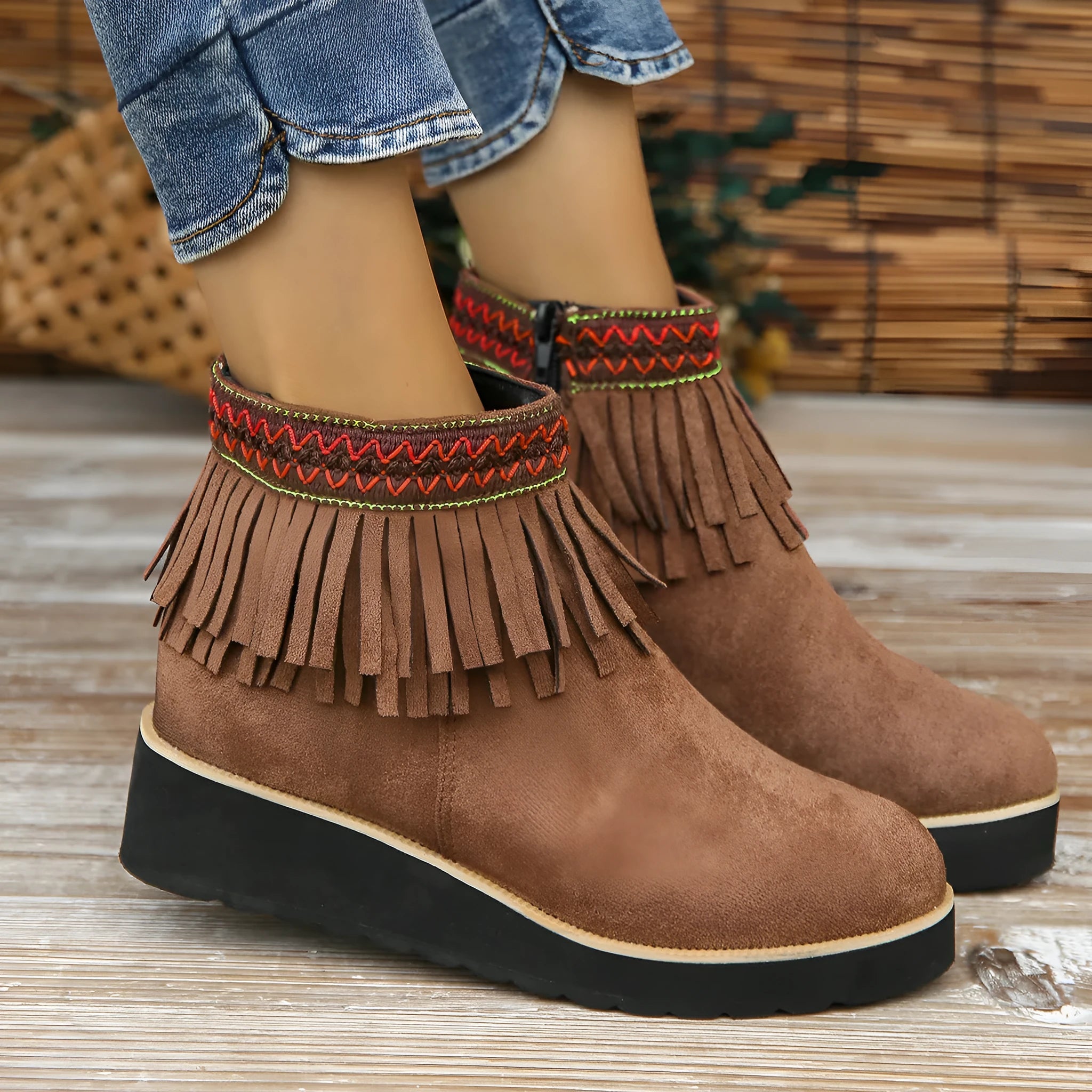 Women's dark brown suede wedge ankle boots with side zip and tassel detail on a thick rubber sole.