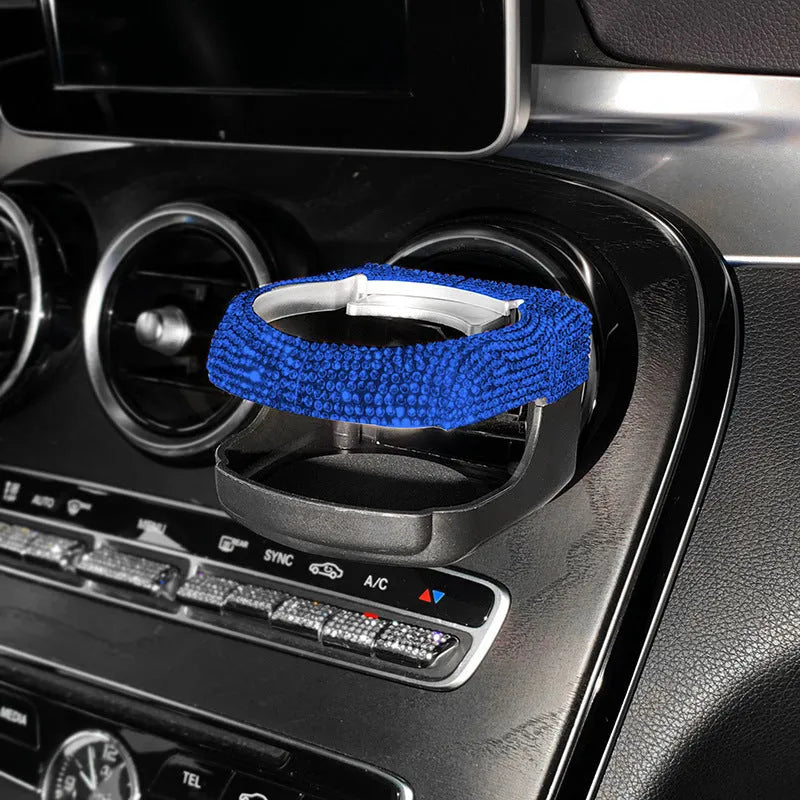Diamond-decorated car cup holder bracket mounted on air vent in blue rhinestone finish