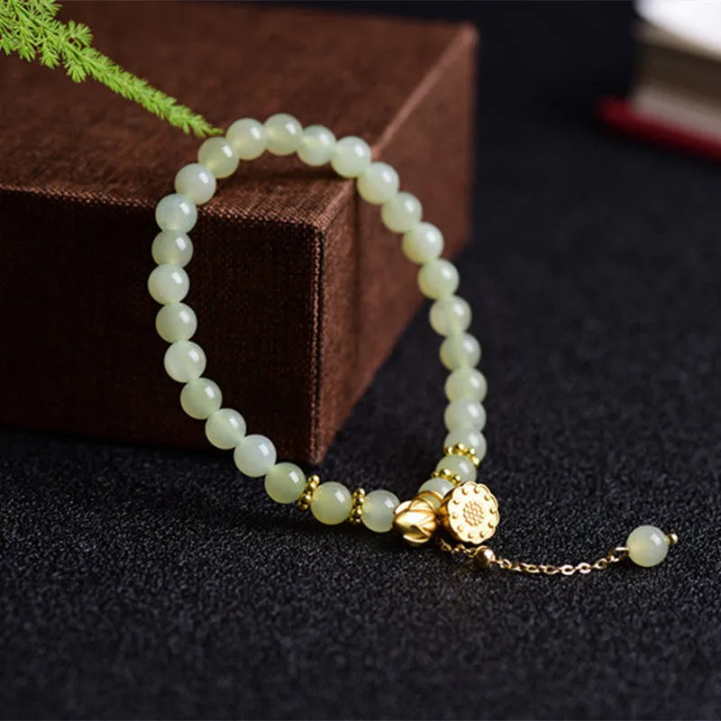 Two Shihuan natural Hetian jade bracelet with 6mm beads, fu charm, and lotus motif on a wrist.