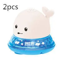 White and blue electric whale bath toy spraying water with flashing lights on a bathroom surface.