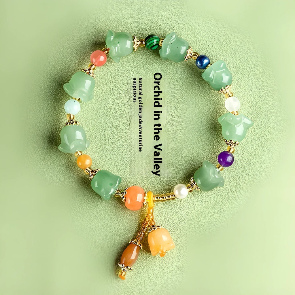 Natural Xinjiang Jinsi Jade aventurine orchid bracelet with carved orchid beads on a wrist.
