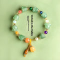 Natural Xinjiang Jinsi Jade aventurine orchid bracelet with carved orchid beads on a wrist.
