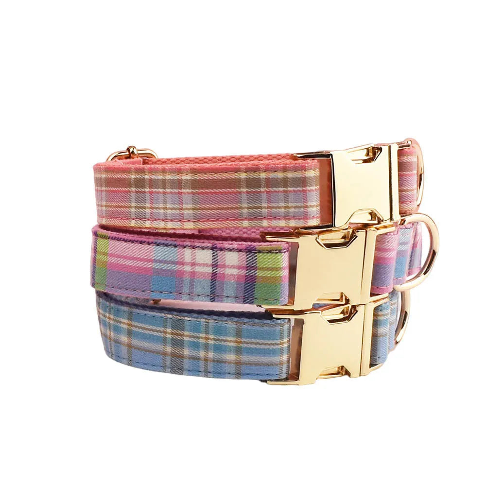 Plaid cloth fabric dog collar, vest, bow tie, and leash set laid out flat.