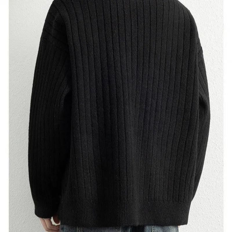 Man wearing a grey textured knit half-zip sweater with a loose fit and long sleeves.