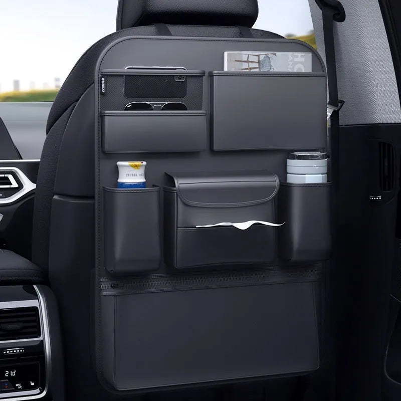 Black leather car seat back storage hanging bag with handle shown behind vehicle seat