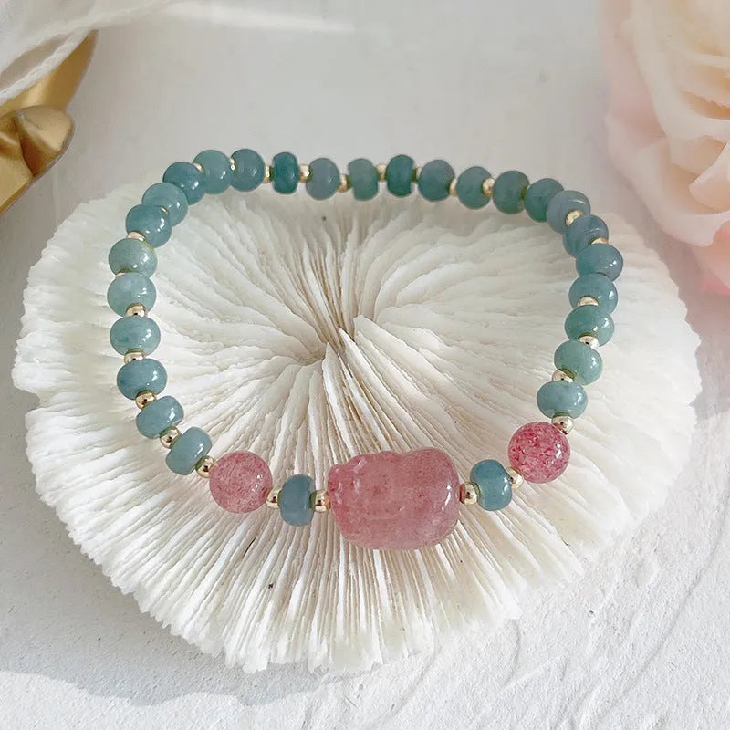Blue-toned jade bracelet with gourd and peace buckle charms and strawberry quartz accents